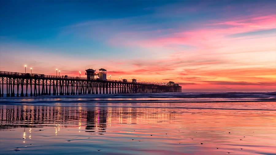Sunrise over coastal pier representing life insurance premium financing strategies for preserving capital